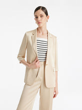 A lady wears a striped top and an oversized blazer.